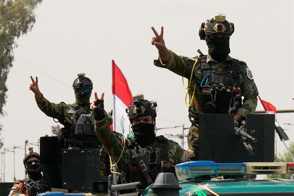 Mit Siegeszeichen: Irakische Sicherheitskräfte fahren in einem Konvoi durch die irakische Hauptstadt, um den vollständigen Abzug der US-Truppen aus dem Irak zu feiern.Hadi Mizban/AP/dpa
