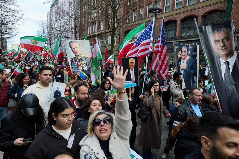 Mit US-Flaggen gingen Demonstranten der iranischen Community in Hamburg auf die Straße.Georg Wendt/dpa