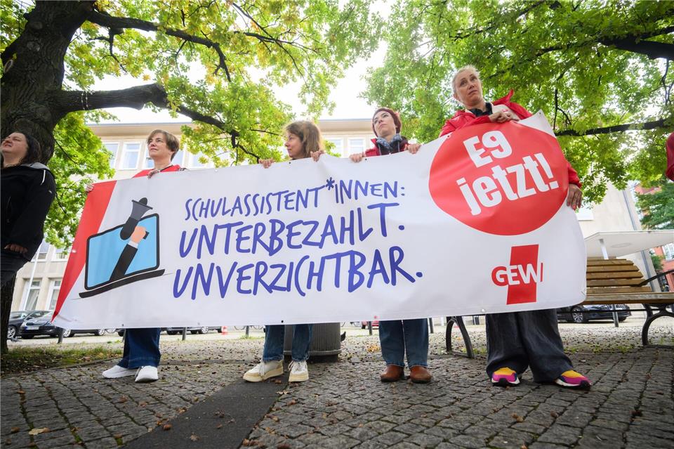 Mit dem Banner „Schulassistent*innen: Unterbezahlt. Unverzichtbar“ protestierten Schulassistentinnen und Schulassistenten vor dem Landtag in Hannover.Jennifer Kramer/dpa