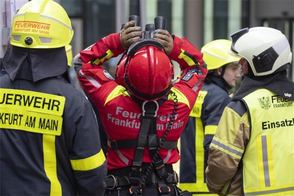 Hangelpartie in schwindelerregenden Höhe Mit dem Fernglas verfolgen Höhenretter der Frankfurter Feuerwehr vom Boden aus den Abstieg vom Extremkletterer Robert. Foto: Boris Roessler
