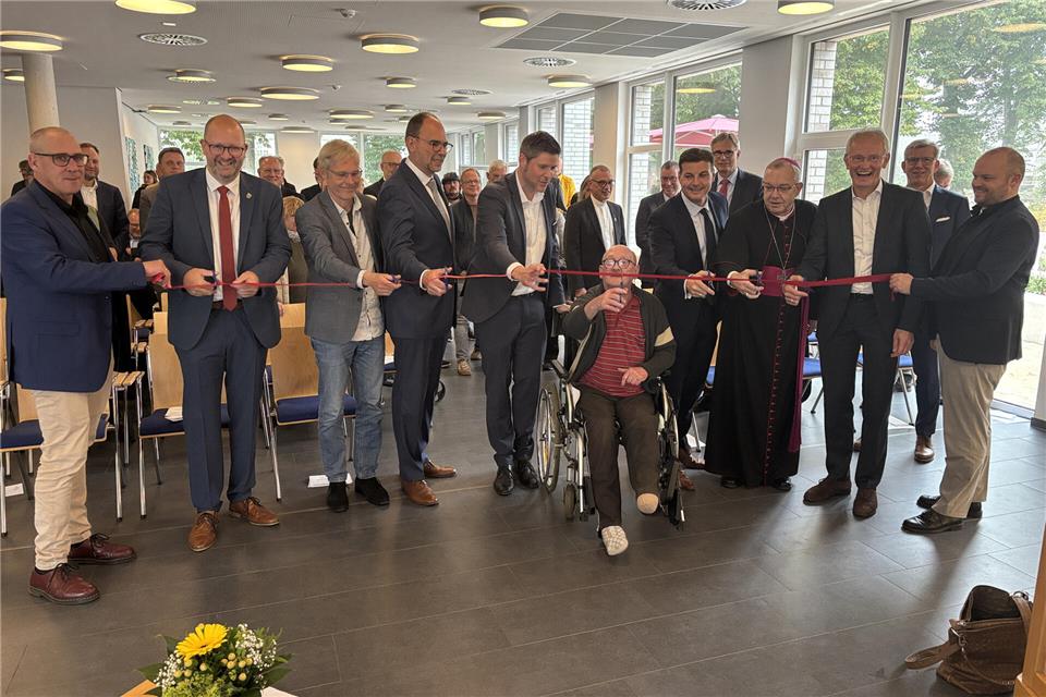 Mit dem Schnitt durchs rote Band haben die Offiziellen, Weihbischof Dr. Christoph Hegge (3. v. r.) und Burkhard Regeling vom Bewohnerbeirat den Neubau am Haus Maria Veen eröffnet.