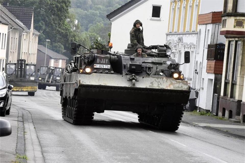 Mit einem Bergepanzer und schwerem Räumgerät rückt die Bundeswehr an, um die Schäden die die Überflutung der Nahmer am Vorabend mit sich gebracht hat, zu beseitigen. Foto: Roberto Pfeil/dpa