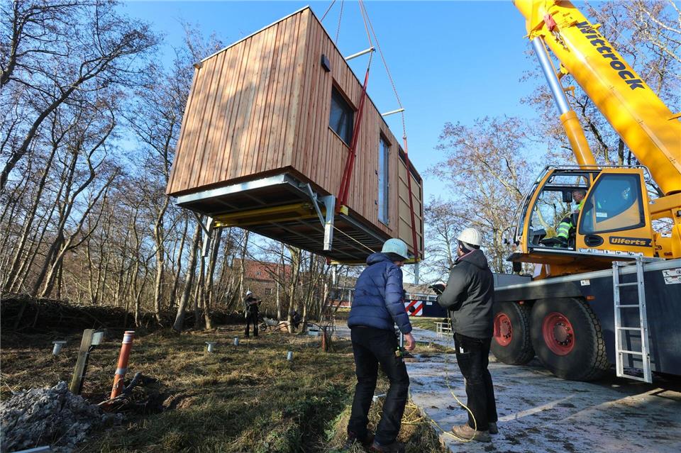 Mit einem Kran werden die Tiny Houses in Position gebracht. Christian Butt/dpa