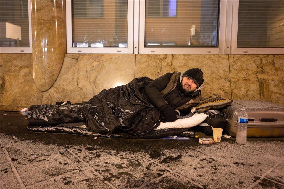 Mit einem Schlafsack schützt sich Andrej gegen die Kälte. Boris Roessler/dpa