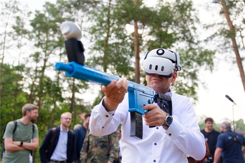 Mit einem Übungsgewehr und einer Virtual-Reality-Brille übt Regierungschef Lies virtuell den Abschuss feindlicher Drohnen.Michael Matthey/dpa