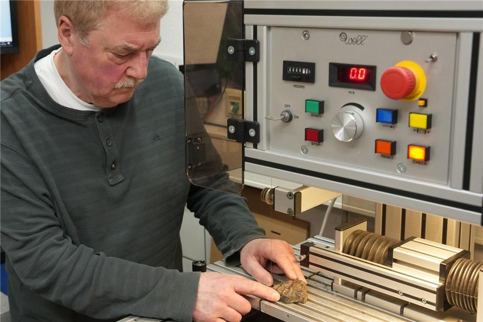 Mit einer Präzisionssäge schneidet Stephan Decker hauchdünne Scheiben von den Steinen ab.Thomas Frey/dpa