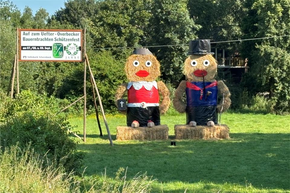 Mit großen Strohfiguren werben die Schützen für ihr Fest.