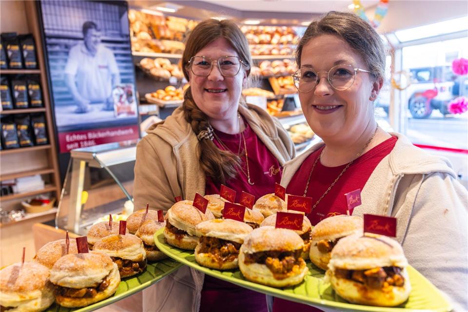 Mit ihrer neuesten Kreation Currywurst-Kreppel wollen die Schwestern Katharina (l) und Theresa (r) Rank für gute Laune in der Fastnachtssaison sorgen.Christian Lademann/dpa