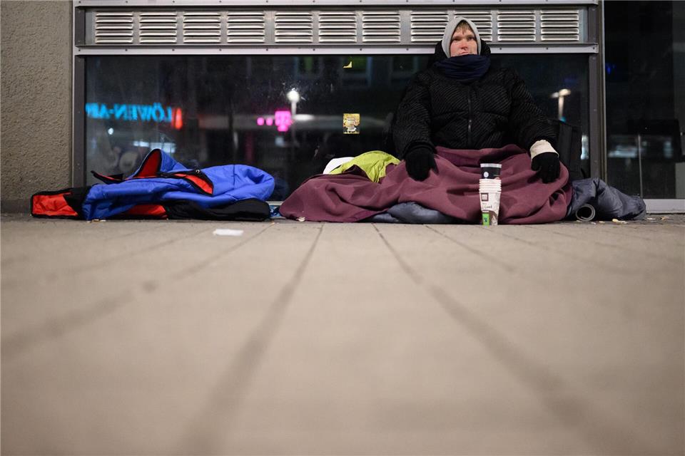 Mit mehreren Jacken, Decken und Schlafsäcken hält sich der Obdachlose Kevin bei der Eiseskälte warm.Julian Stratenschulte/dpa