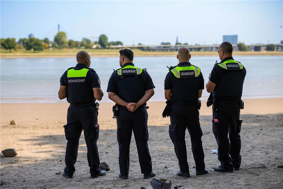 Mitarbeiter des Düsseldorfer Ordnungsamtes kontrollieren das Badeverbot im Rhein. Christoph Reichwein/dpa