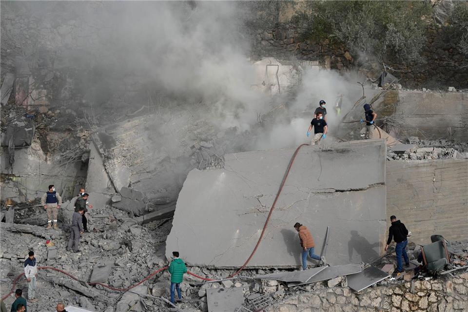 Mitarbeiter des Zivilschutzes und Zivilisten überprüfen ein zerstörtes Gebäude, das von einem israelischen Luftangriff in dem Ort im Südlibanon getroffen wurde.Mohammad Zaatari/AP/dpa