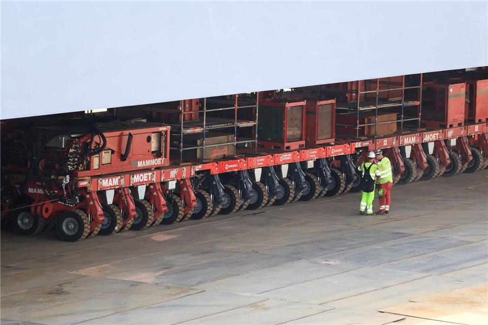 Mitarbeiter kontrollieren die Räder der Transportmodule.Christian Charisius/dpa