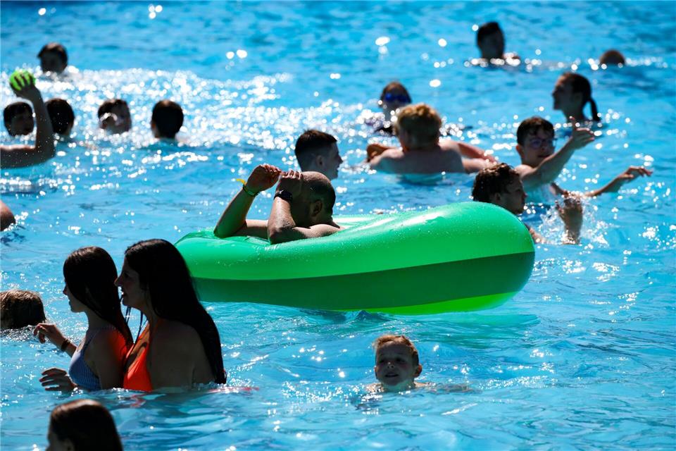 Mitarbeiter von Freibädern beobachten immer wieder Eltern, die auf ihr Handy statt auf ihr Kind im Wasser schauen. (Archivbild)Christoph Reichwein/dpa