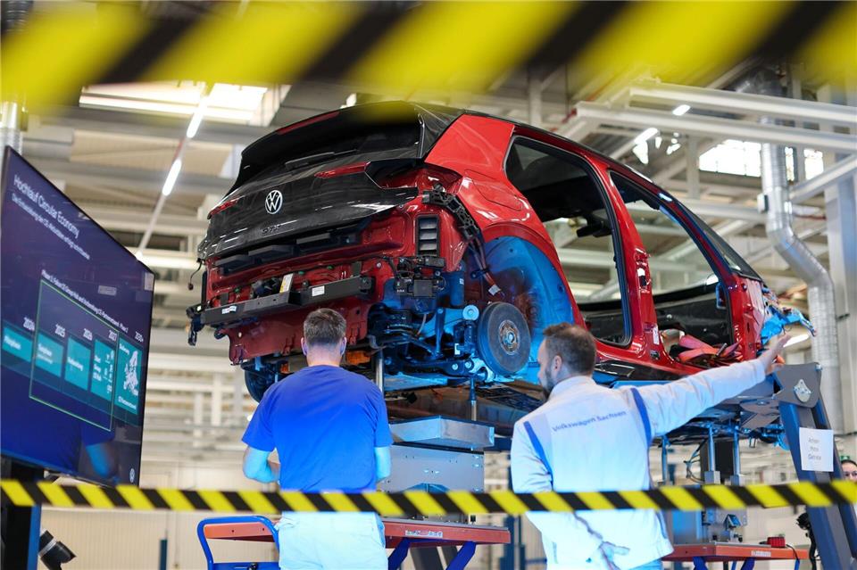 Mitarbeiter von Volkswagen in Zwickau zerlegen einen VW ID.3. Jan Woitas/dpa