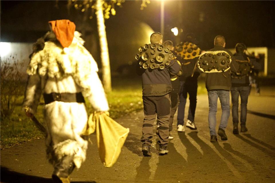 Mitglieder der Brauchtumsgruppe Weihnachtsmänner e.V. laufen mit Schellengeläut auf dem Weihnachtsmarkt in Altenbrak.Matthias Bein/dpa