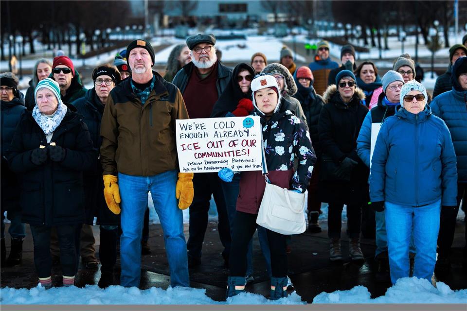 Mitglieder der Gemeinde stehen während einer Mahnwache zu Ehren einer Frau, die von einem ICE-Beamten in Minneapolis erschossen wurde, vor dem Minnesota State Capitol zusammen.Kerem Yücel/Minnesota Public Radio/AP/dpa