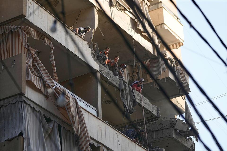 Mitglieder des libanesischen Zivilschutzes untersuchen Schäden in getroffener Wohnung in südlichem Vorort von Beirut. Bilal Hussein/AP/dpa