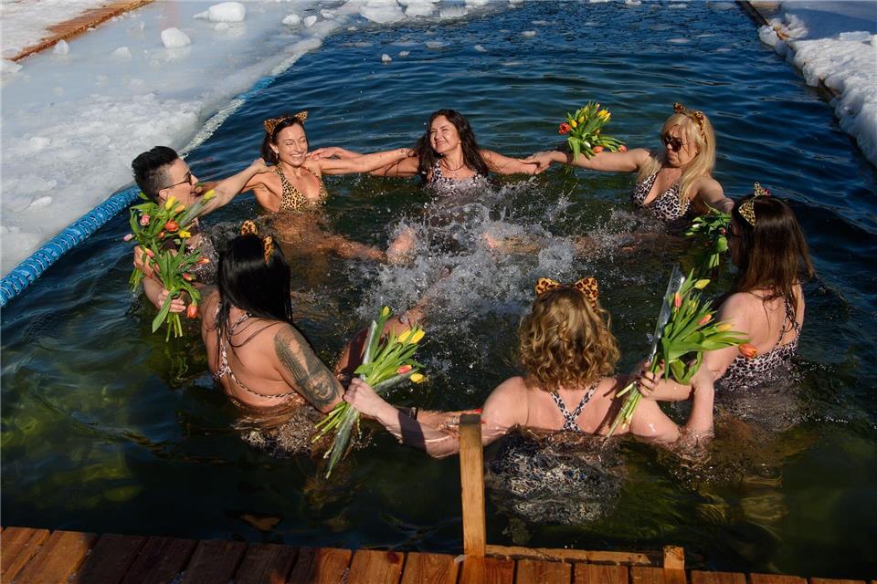 Mitglieder eines Winterschwimmclubs feiern in einem Eisloch den Internationalen Frauentag.Yauhen Yerchak/SOPA Images via ZUMA Press Wire/dpa