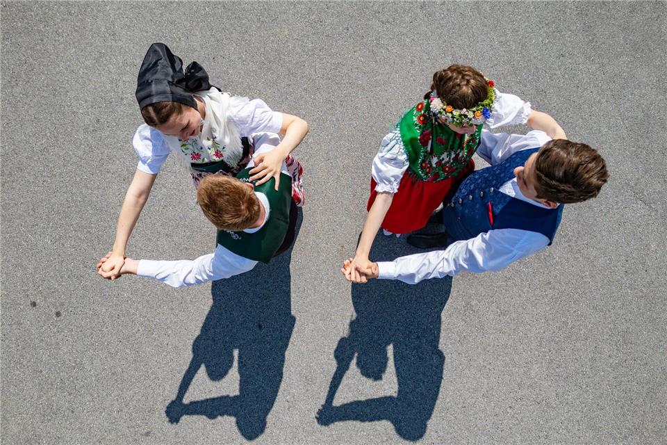 Mitglieder vom Sorbischen Folkloreensemble Höflein und der Vokstanzgruppe Schmerlitz tanzen im Rahmen eines Pressetermins zum XV. Internationalen Folklorefestival Łužica-Łužyca-Lausitz in katholischer Festtagstracht und in der Volkstanztracht auf der Straße.Robert Michael/dpa
