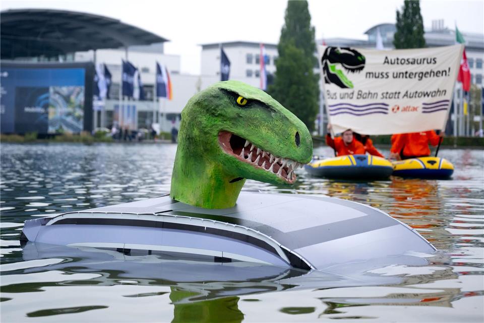Mitglieder von Attac demonstrieren vor der Eröffnung der Internationalen Automobil-Ausstellung (IAA Mobility) in München mit einem „Autosaurus“ für eine Mobilitätswende.Sven Hoppe/dpa