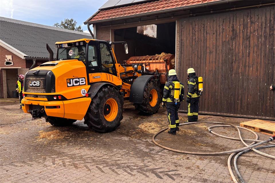 Mithilfe eines Radladers wird das Stroh aus der Scheune gebracht. 