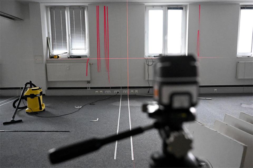 Mithilfe von Klebestreifen markieren die Architektinnen, wo auf der Fläche Wände installiert werden sollen.Lilli Förter/dpa