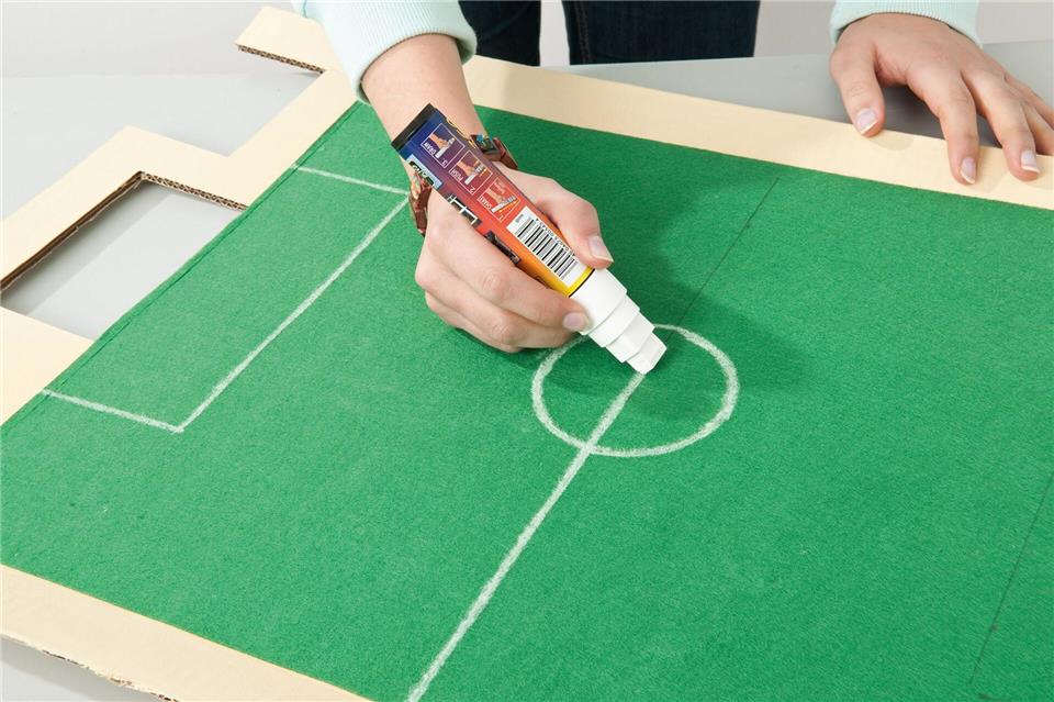Mittellinie, Mittelkreis und Torräume erst vorzeichnen, dann mit weißem Textilstift sauber nachziehen.-/Tesa/DIY Academy/dpa-tmn
