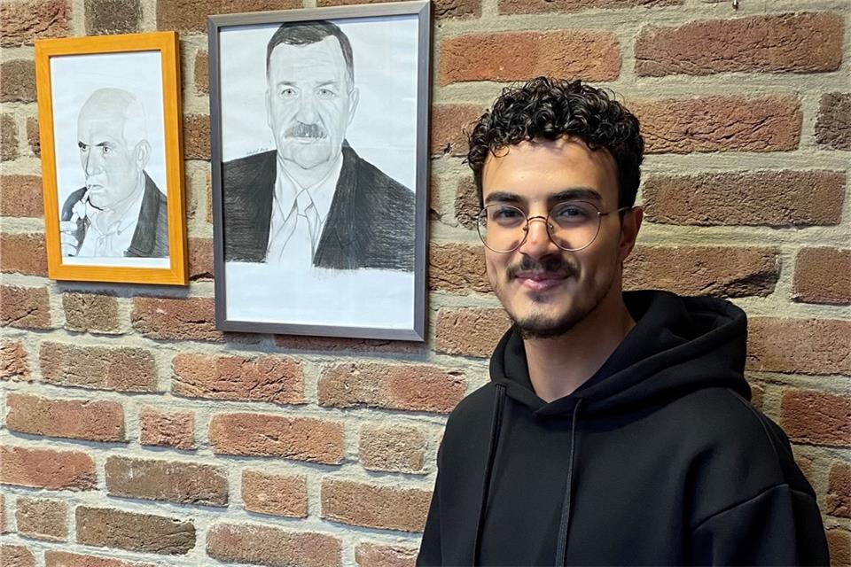 Mohamad Meree zeigt einige seiner Portrait-Zeichnungen.
