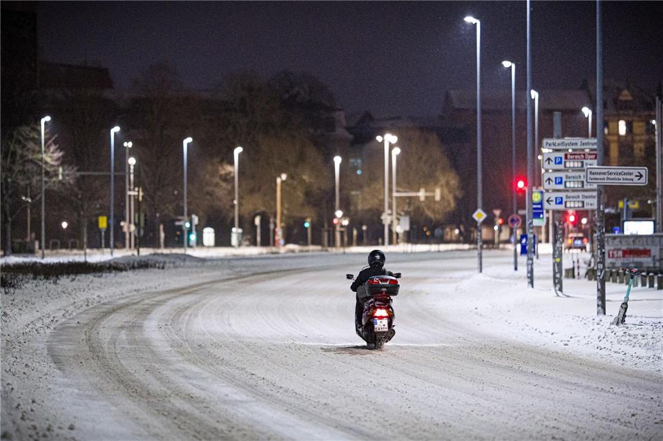 Motorroller kämpft sich am frühen Morgen durch Schnee im Stadtzentrum in HannoverMoritz Frankenberg/dpa