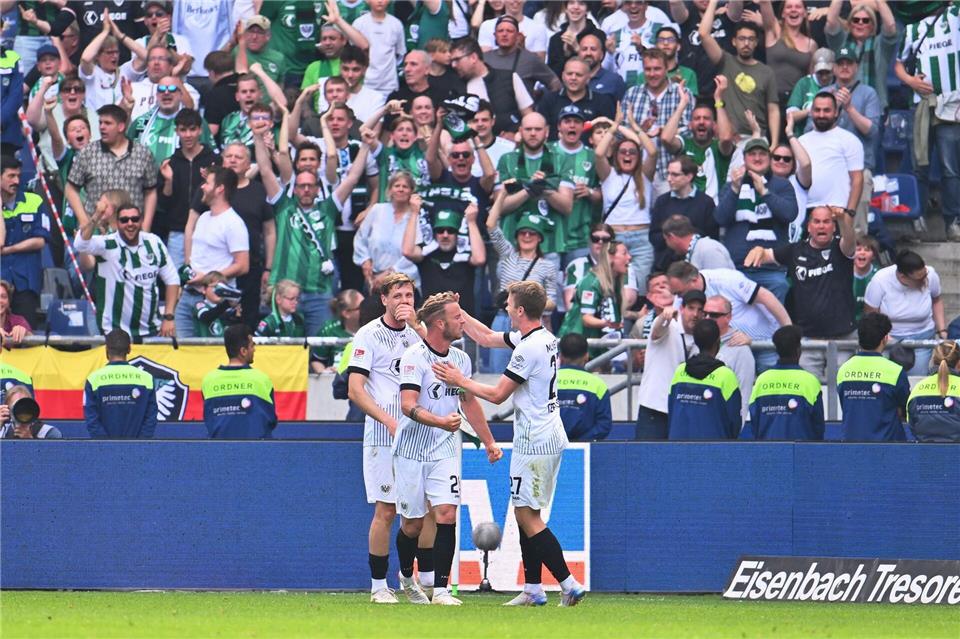 Münsters Spieler bejubeln das Tor zum 3:3 in Hannover.Swen Pförtner/dpa