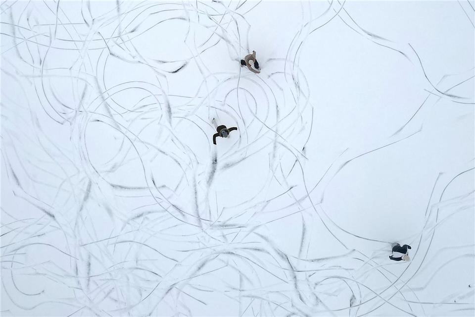 Muster im Schnee: Eine Luftaufnahme zeigt Schlittschuhläufer auf einem zugefrorenen See in Österreich.Helmut Fohringer/APA/dpa