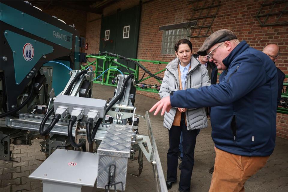 NRW-Agrarministerin Silke Gorißen lässt sich einen neuen, sogenannten Hackroboter erklären. Oliver Berg/dpa
