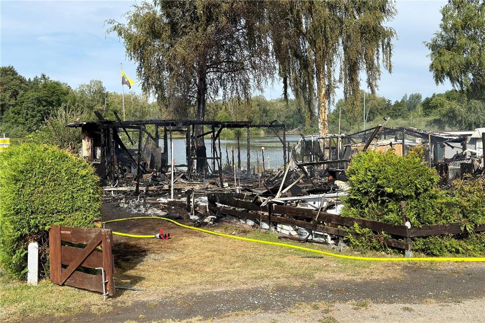 Nach dem Brand bleiben ausgebrannte Campingwagen und verkohlte Zelte zurück. Daniel Löb/dpa