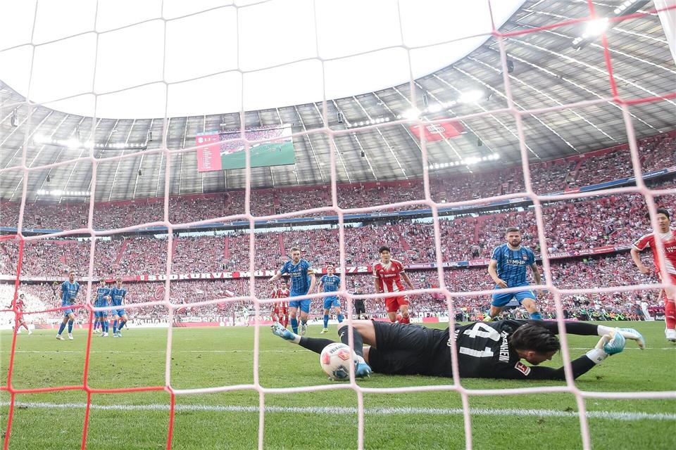 Nach dem Schuss von Michael Olise prallt der Ball vom Pfosten an den Fuß von Heidenheims Torwart Diant Ramaj und von dort zum 3:3 ins Tor. Harry Langer/dpa