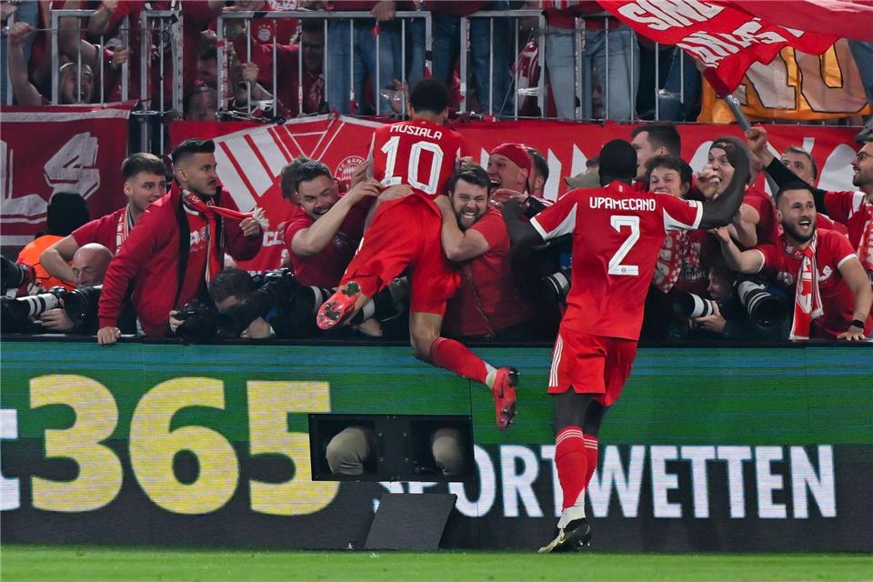 Nach dem letzten Bayern-Tor gegen Real springen einige Münchner Fans und Bayern-Profi Jamal Musiala im Jubel den anwesenden Fotografen in den Rücken.Sven Hoppe/dpa