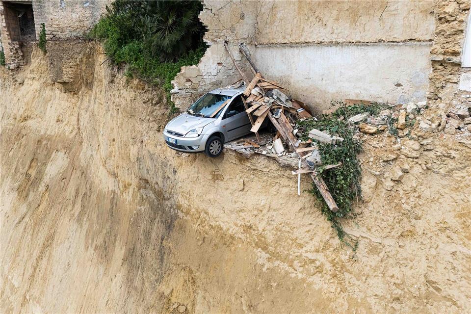 Nach dem schweren Erdrutsch auf Sizilien hängt ein Auto über einem Abgrund. Andrea Petrelli/IPA via ZUMA Press/dpa