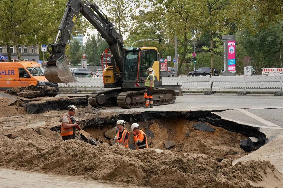 Nach einem Wasserrohrbruch in Hamburg in der Amsinckstraße arbeiten Bauarbeiter in einem Loch.Gerald Wintzer/dpa
