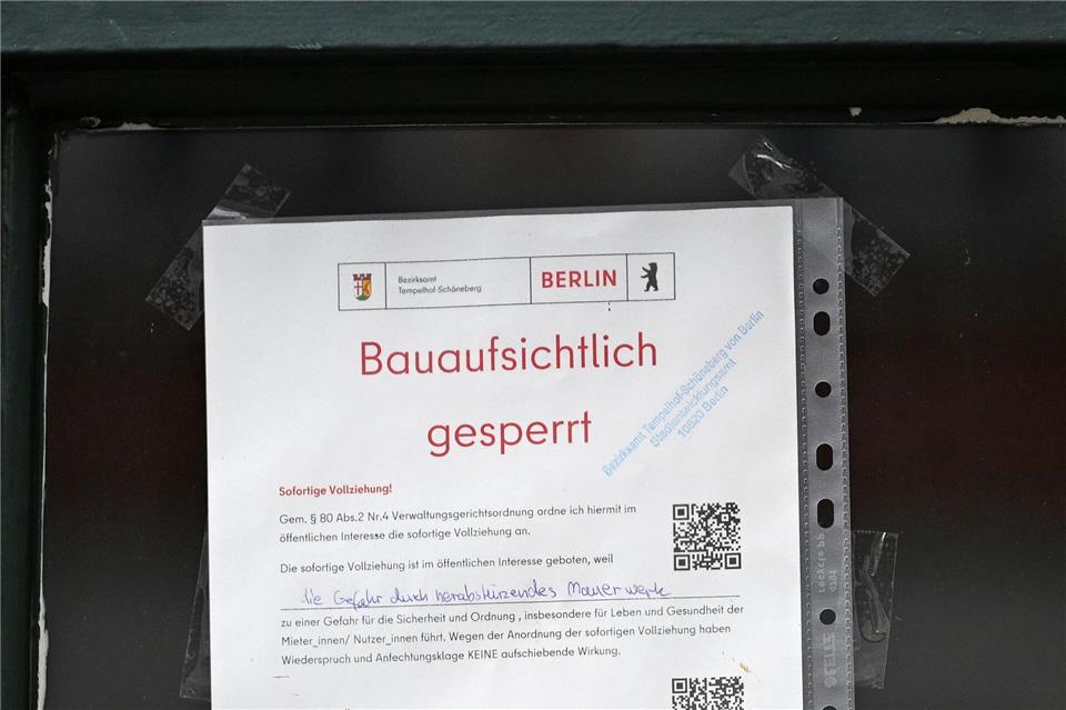 Nach einer Explosion hängt ein Schild zur Sperrung an der Tür eines Wohnhauses in Berlin-Schöneberg.Michael Brandt/dpa