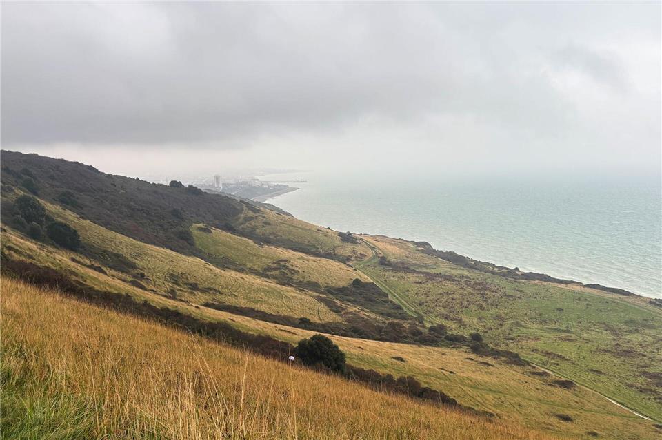 Warum Südengland im Oktober besonders entspannend ist  Nach fünf Stunden Fußweg tut sich hinter einem grünen Hügel das Ziel auf: Eastbourne liegt verwaschen da. Nathalie Helene Rippich/dpa-tmn