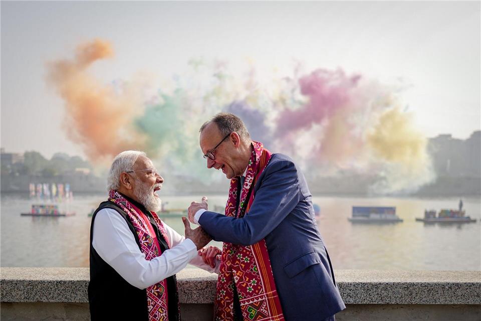 Narendra Modi, Premierminister von Indien, und Bundeskanzler Friedrich Merz (r, CDU) stehen am Rande eines Drachenfestivals vor einem Feuerwerk am Ufer des Sabarmati in Ahmedabad.Kay Nietfeld/dpa