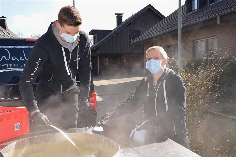 Natalie Labod und Elias Stadtler vom Team Wachtmeister verteilen Erbsensuppe aus einem Riesenpott