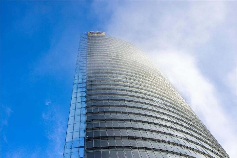 Nebelschwaden ziehen an der DHL-Zentrale am Posttower vorbei. Oben ist das Logo für das Briefgeschäft zu sehen, das Posthorn.Thomas Banneyer/dpa