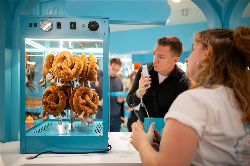 Neben Bratwürsten, Zuckerwatte und Eiskaffee gibt es auch Brezeln aus Plüsch.Sebastian Christoph Gollnow/dpa