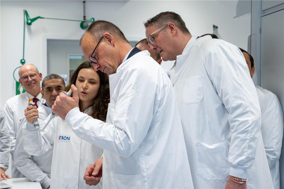 Nein, pipettiert habe er noch nie, sagt Kanzler Merz (Mitte) und bekommt es von einer Doktorandin erklärt. Harald Tittel/dpa