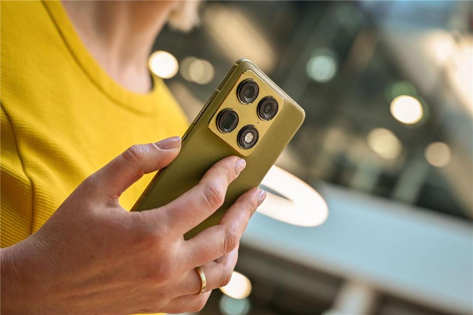 Nicht nur Technik, auch Look: Martini Olive heißt die Pantone-Farbe des Motorola Signature, die sich gut mit dem Gelb des Oberteils verträgt. Nico Tapia/dpa-tmn