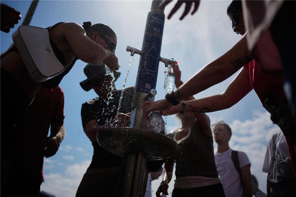 Nicht nur in Paris scharen sich die Menschen in diesem Sommer um Trinkbrunnen. (Archivbild)Christophe Ena/AP/dpa