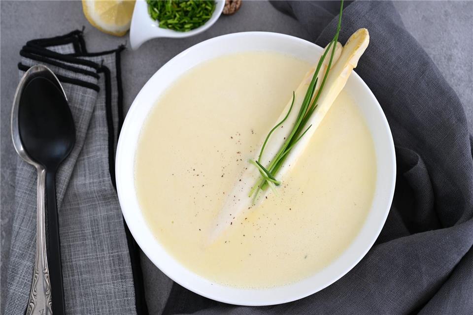 Nicht wegschütten: Aus dem Sud der gekochten Spargelstangen lässt sich schnell noch ein Spargelsüppchen zubereiten. Als Garnitur zwei Spargelstangen einfach mit Schnittlauch verschnüren. Julia Uehren/loeffelgenuss.de/dpa-tmn
