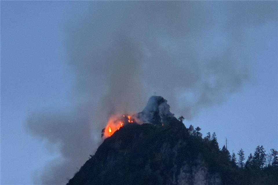 Noch immer steigen große Rauchwolken aus einem bewaldeten Berg bei Ruhpolding (Landkreis Traunstein) auf.Matthias Brüning/dpa