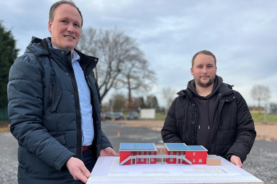 Norbert Altrogge und Pascal Becker halten das Modell von der zukünftigen Flüchtlingsunterkunft an der Dorstener Straße in Erle.