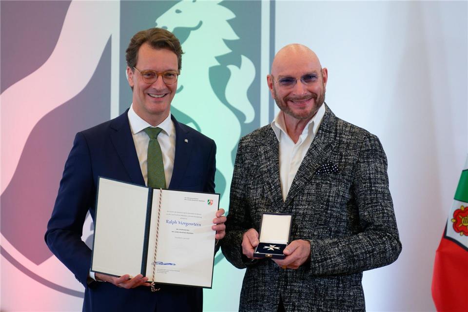 Nordrhein-Westfalens Ministerpräsident Hendrik Wüst (CDU, l) verleiht den Verdienstorden des Landes Nordrhein-Westfalen an den Moderator Ralph Morgenstern.Henning Kaiser/dpa
